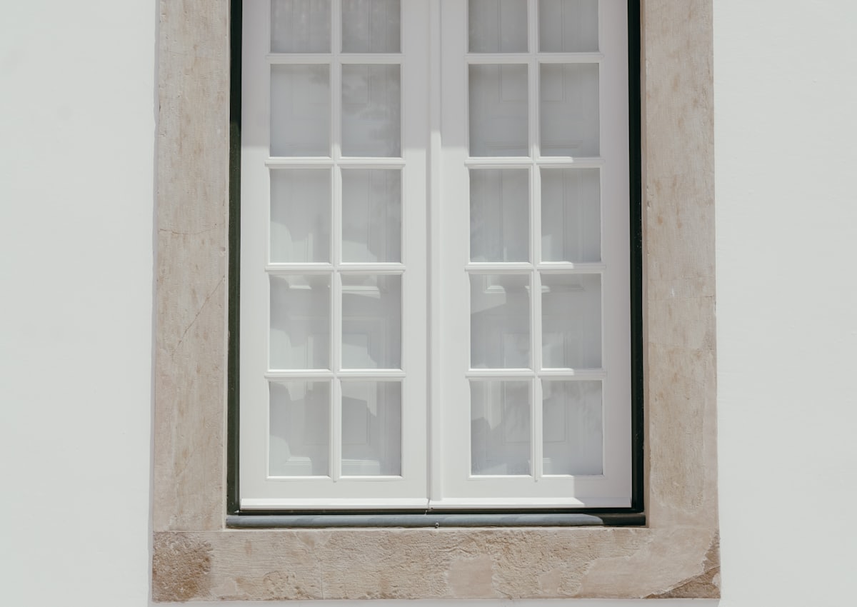 White window with slim glazing bars set into a stone surround