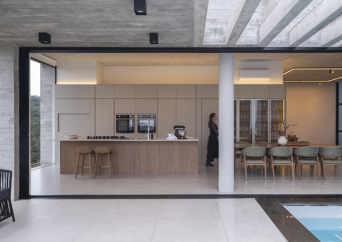 Wide glazed opening folded fully back to connect a kitchen with a terrace