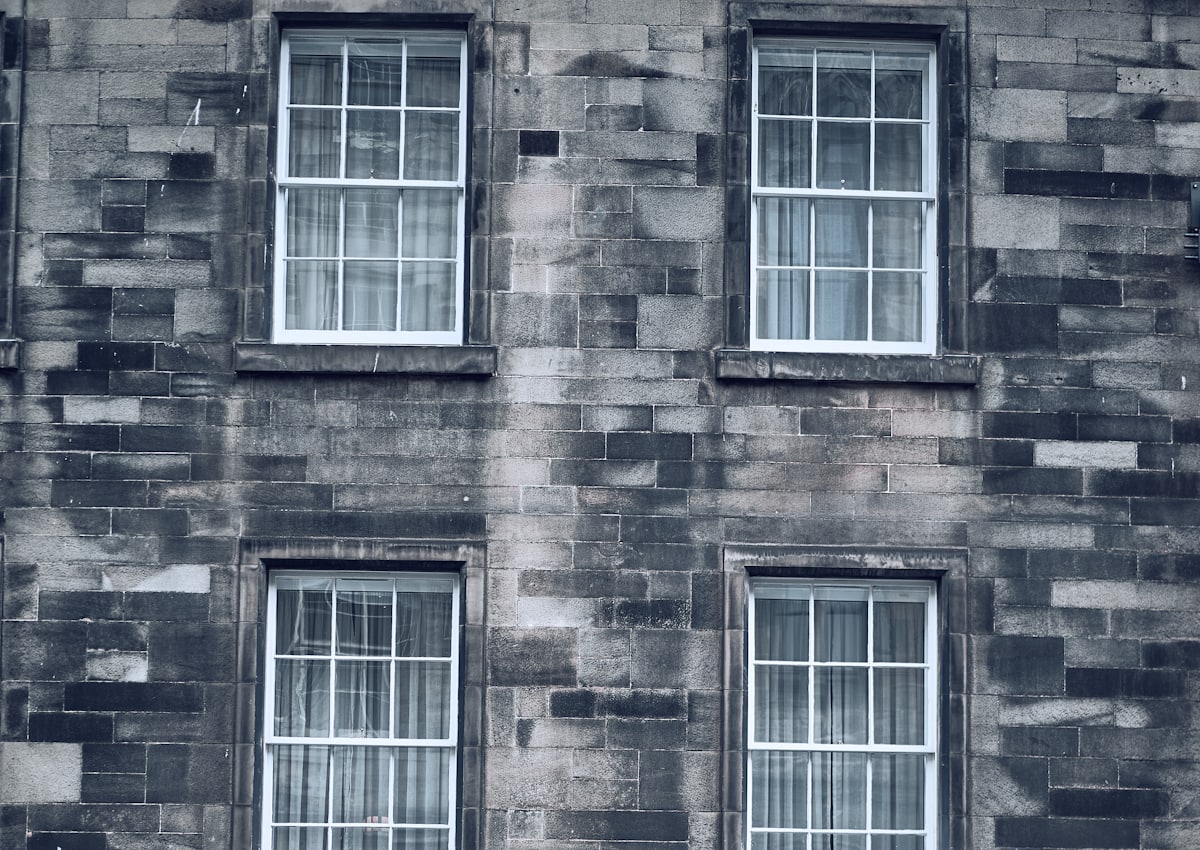White sash windows with glazing bars set into a stone building facade